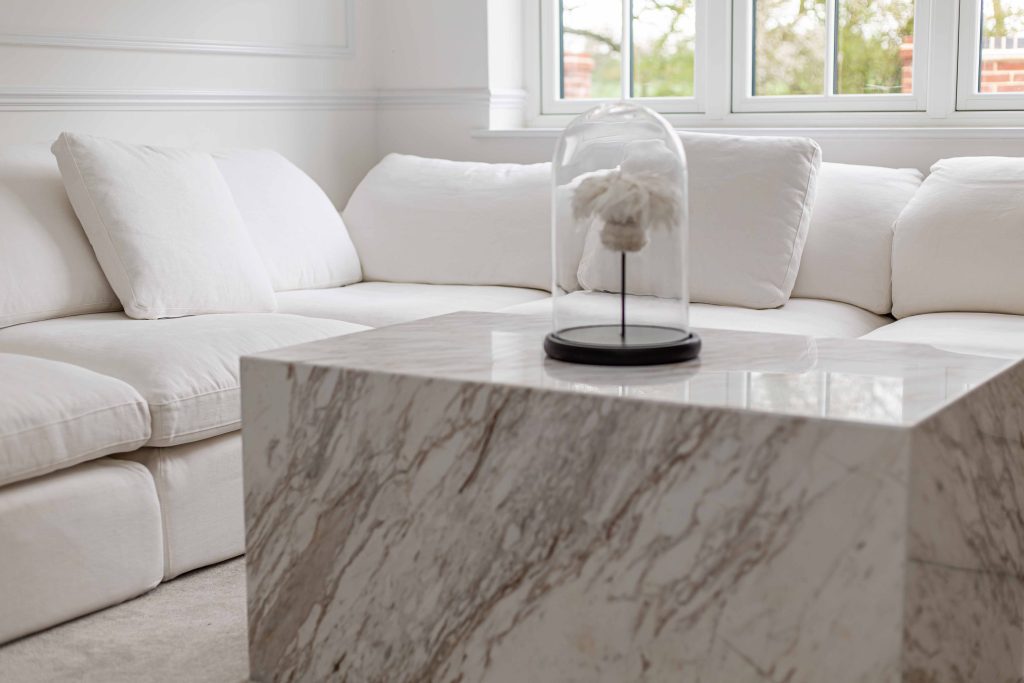Commercial photography and videography in Essex - DC Media - Marble Coffee table in white and cream. A large white corner sofa is behind it and a large window letting in light